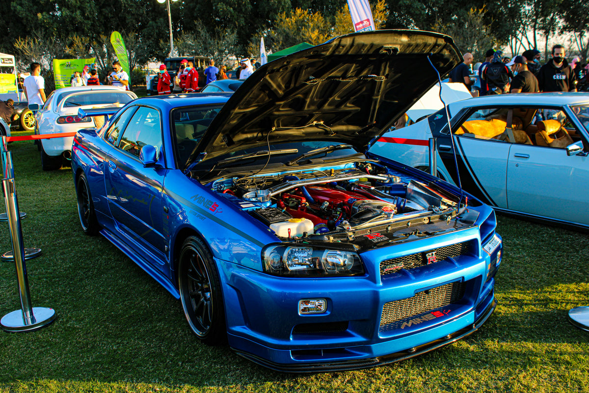 Blue car with open hood at a car show